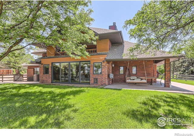 7975 Anchor Dr, Longmont, CO 80504 - rear view of property with a patio, roof with shingles, a chimney, and brick siding