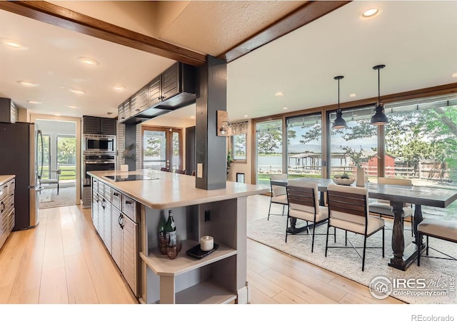 7975 Anchor Dr, Longmont, CO 80504 - kitchen with appliances with stainless steel finishes, open shelves, light countertops, light wood-style floors, and a kitchen island