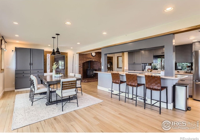 7975 Anchor Dr, Longmont, CO 80504 - dining room with light wood finished floors, recessed lighting, and a wood stove