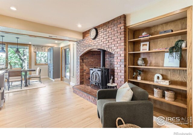 7975 Anchor Dr, Longmont, CO 80504 - living area featuring a wood stove, wood finished floors, and recessed lighting