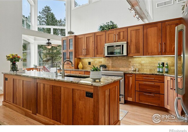 178 Balsam Ln, Boulder, CO 80304 - kitchen featuring stainless steel appliances, light wood-style floors, a high ceiling, brown cabinetry, and track lighting