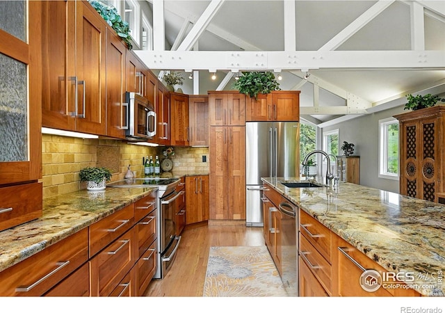 178 Balsam Ln, Boulder, CO 80304 - kitchen with stainless steel appliances, light wood-type flooring, light stone countertops, brown cabinets, and tasteful backsplash