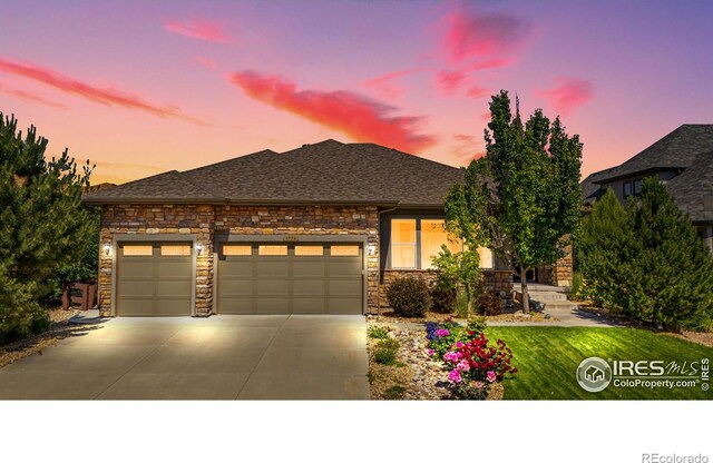 1976 Cayman Dr, Windsor, CO 80550 - view of front of property with a garage, stone siding, concrete driveway, and roof with shingles