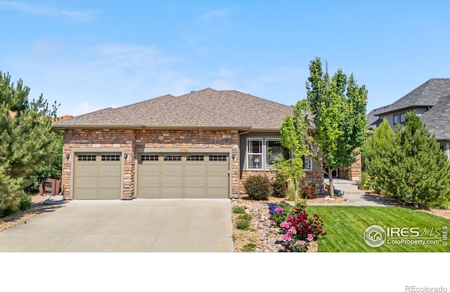 1976 Cayman Dr, Windsor, CO 80550 - view of front of home featuring a garage, concrete driveway, stone siding, a front yard, and a shingled roof