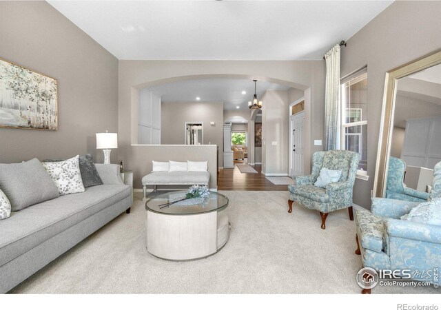 1976 Cayman Dr, Windsor, CO 80550 - living room featuring arched walkways, carpet flooring, a chandelier, and recessed lighting