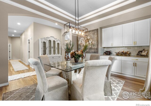 1976 Cayman Dr, Windsor, CO 80550 - dining space with light wood finished floors, crown molding, a chandelier, and recessed lighting