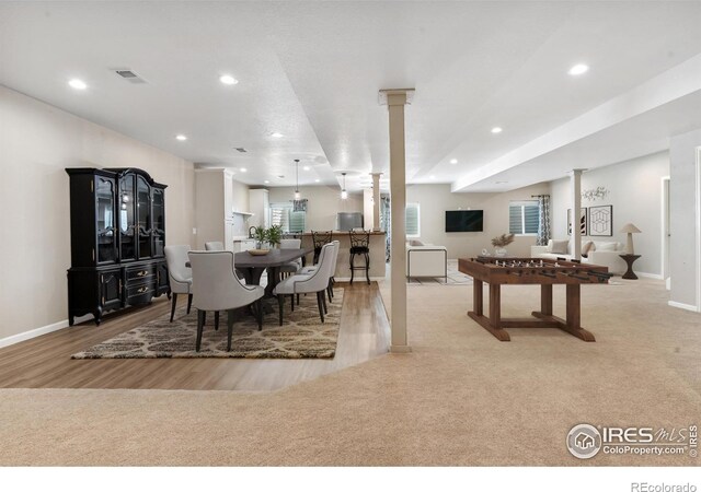 1976 Cayman Dr, Windsor, CO 80550 - carpeted dining space featuring ornate columns, wood finished floors, and recessed lighting