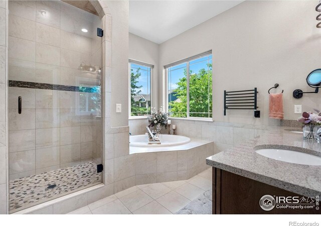 1976 Cayman Dr, Windsor, CO 80550 - bathroom featuring a shower stall, a garden tub, double vanity, and tile patterned floors