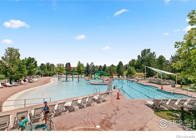 1662 Crestview Ln, Erie, CO 80516 - community pool with a water slide, view of wooded area, and a patio area