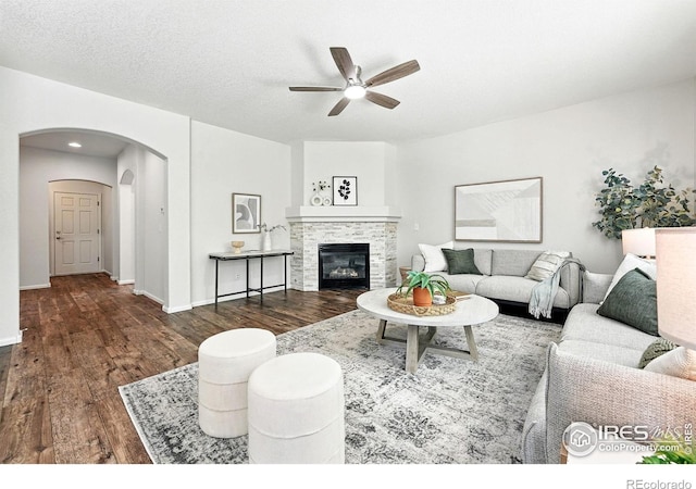 1662 Crestview Ln, Erie, CO 80516 - living area with a ceiling fan, wood finished floors, arched walkways, and a fireplace