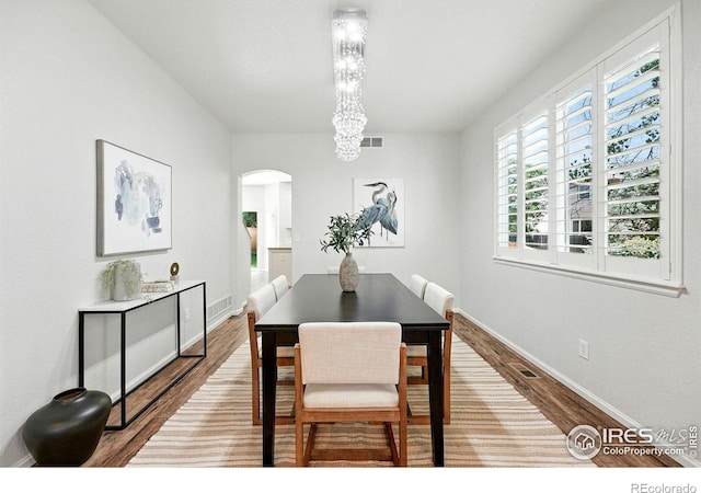 1662 Crestview Ln, Erie, CO 80516 - dining room featuring arched walkways, wood finished floors, and a chandelier
