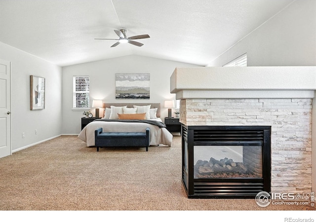 1662 Crestview Ln, Erie, CO 80516 - carpeted bedroom featuring vaulted ceiling, a fireplace, and a ceiling fan