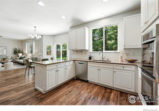 1662 Crestview Ln, Erie, CO 80516 - kitchen featuring stainless steel appliances, plenty of natural light, a peninsula, white cabinets, and recessed lighting