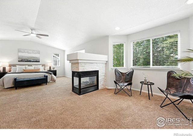 1662 Crestview Ln, Erie, CO 80516 - bedroom featuring carpet floors, multiple windows, a multi sided fireplace, lofted ceiling, and a ceiling fan