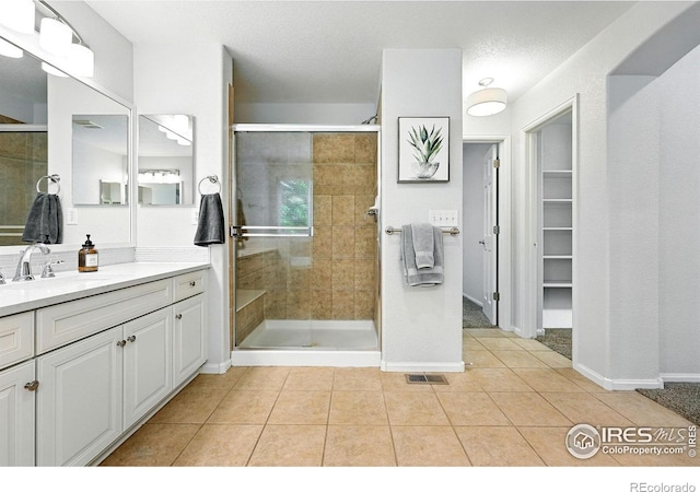 1662 Crestview Ln, Erie, CO 80516 - full bathroom featuring a stall shower, vanity, tile patterned flooring, and a spacious closet