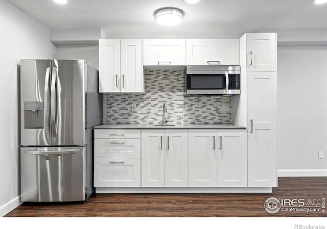 1662 Crestview Ln, Erie, CO 80516 - kitchen featuring stainless steel appliances, white cabinets, backsplash, dark wood-style floors, and recessed lighting