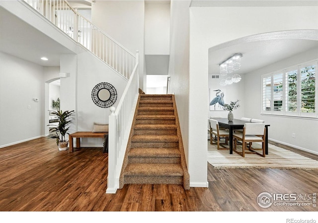 1662 Crestview Ln, Erie, CO 80516 - stairs featuring arched walkways, wood finished floors, and a high ceiling