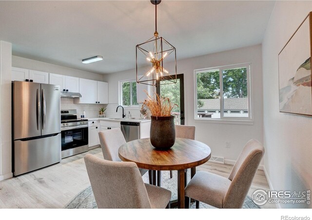 1206 Dawn Ave, Gilcrest, CO 80623 - dining room with light wood-type flooring and a chandelier