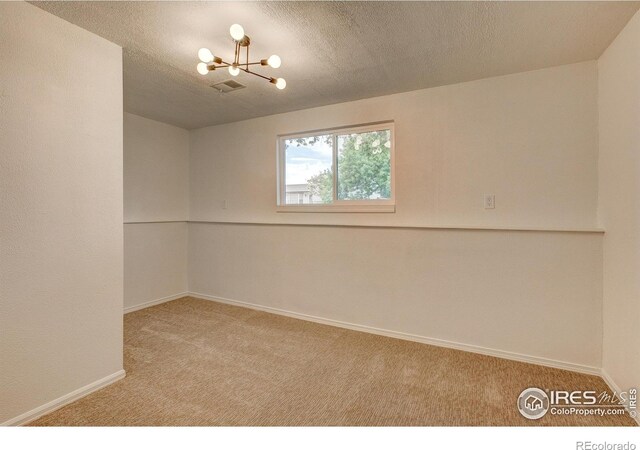 1206 Dawn Ave, Gilcrest, CO 80623 - carpeted empty room featuring a chandelier and a textured ceiling