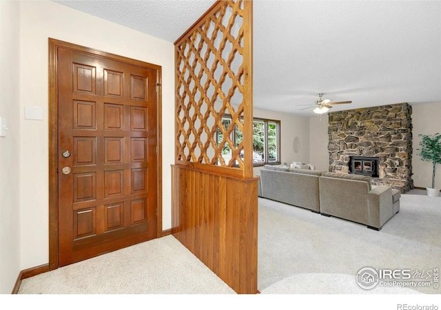 609 Endicott St, Fort Collins, CO 80524 - foyer entrance featuring carpet floors, a ceiling fan, and a stone fireplace
