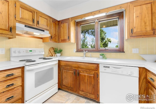 609 Endicott St, Fort Collins, CO 80524 - kitchen with white appliances, under cabinet range hood, light countertops, and brown cabinets