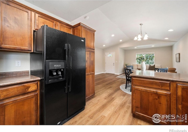 1879 Gemini Ct, Loveland, CO 80537 - kitchen with black refrigerator with ice dispenser, brown cabinets, light wood finished floors, a chandelier, and hanging light fixtures