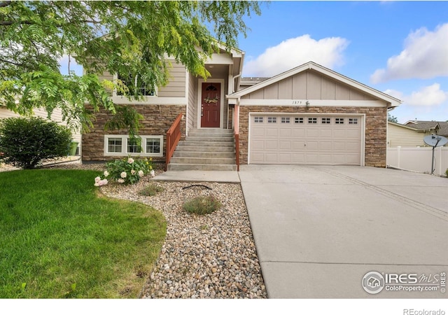1879 Gemini Ct, Loveland, CO 80537 - view of front of home featuring stone siding, a garage, driveway, and board and batten siding