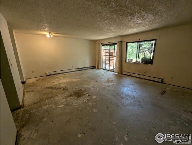 2919 Riverside Dr, Idaho Springs, CO 80452 - spare room with a baseboard radiator, a textured ceiling, and unfinished concrete floors