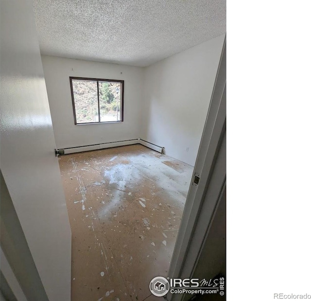 2919 Riverside Dr, Idaho Springs, CO 80452 - empty room with a baseboard heating unit and a textured ceiling