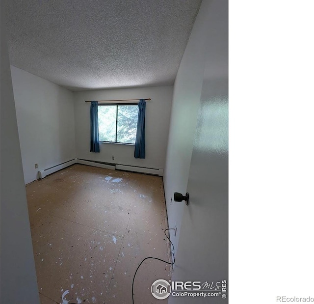 2919 Riverside Dr, Idaho Springs, CO 80452 - empty room with a textured ceiling and baseboard heating