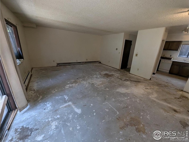 2919 Riverside Dr, Idaho Springs, CO 80452 - unfurnished living room featuring a textured ceiling, baseboard heating, concrete floors, and a baseboard radiator