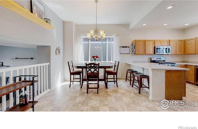 1661 Rise Dr, Windsor, CO 80550 - kitchen featuring appliances with stainless steel finishes, a chandelier, light countertops, a peninsula, and a kitchen breakfast bar