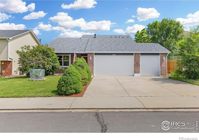 629 Sumac St, Frederick, CO 80530 - view of front facade featuring a garage, brick siding, driveway, and a shingled roof