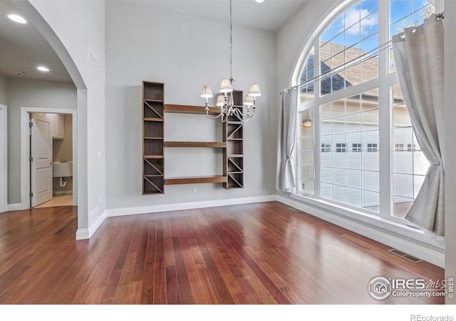 64 Bachar Dr, Fort Morgan, CO 80701 - unfurnished dining area with healthy amount of natural light, arched walkways, a chandelier, wood-type flooring, and recessed lighting