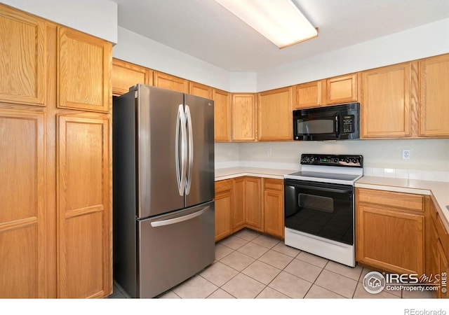 2120 Timber Creek Dr Unit 5, Fort Collins, CO 80528 - kitchen with black microwave, freestanding refrigerator, range with electric stovetop, light countertops, and light tile patterned floors