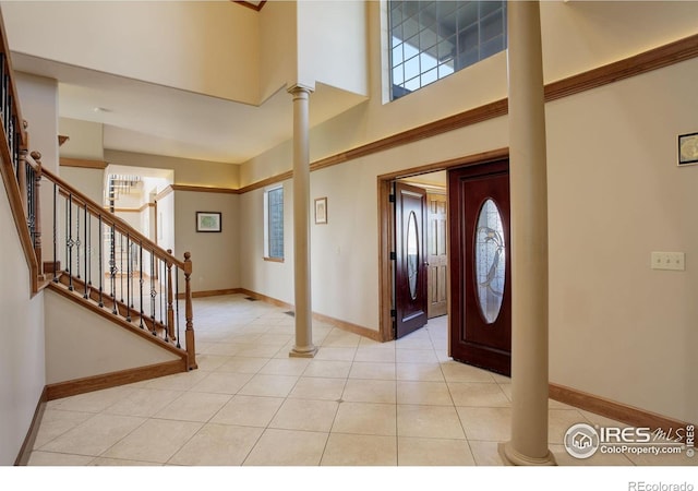 14448 Hanover St, Brighton, CO 80602 - foyer entrance with plenty of natural light, decorative columns, a towering ceiling, stairway, and light tile patterned flooring