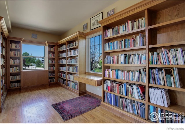 14448 Hanover St, Brighton, CO 80602 - sitting room featuring wall of books, healthy amount of natural light, and wood-type flooring