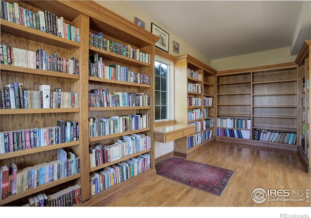 14448 Hanover St, Brighton, CO 80602 - sitting room with wall of books and wood finished floors