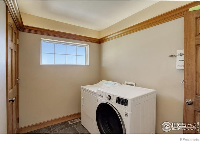 14448 Hanover St, Brighton, CO 80602 - laundry area featuring washing machine and dryer and dark tile patterned flooring