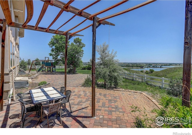 14448 Hanover St, Brighton, CO 80602 - view of patio with a pergola, a playground, a water view, and outdoor dining area