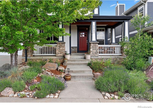 1043 Terrace Cir S, Boulder, CO 80304 - entrance to property featuring a porch, stone siding, and a chimney