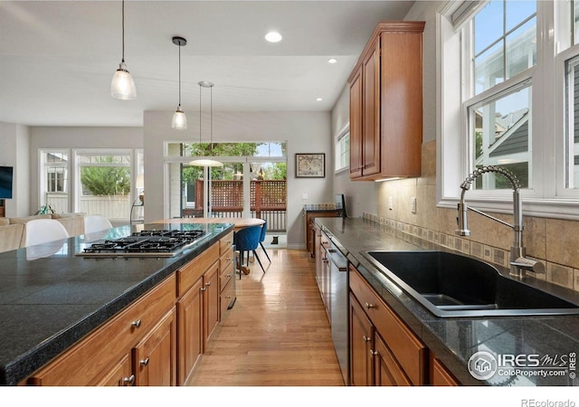 1043 Terrace Cir S, Boulder, CO 80304 - kitchen featuring appliances with stainless steel finishes, light wood-type flooring, brown cabinets, dark countertops, and hanging light fixtures