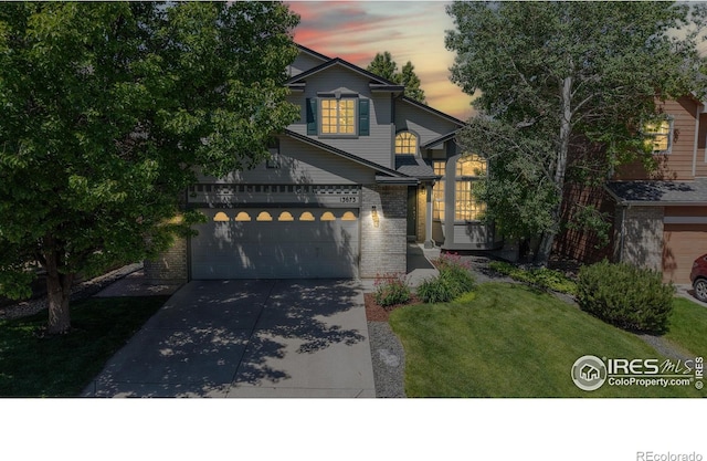 13673 Cook St, Thornton, CO 80602 - traditional-style house featuring brick siding, driveway, a front yard, and a garage