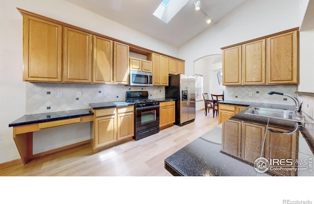 13673 Cook St, Thornton, CO 80602 - kitchen with appliances with stainless steel finishes, open shelves, lofted ceiling, light wood finished floors, and a skylight