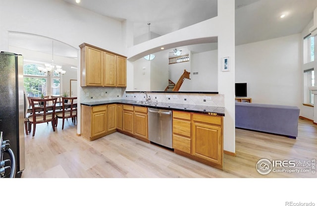 13673 Cook St, Thornton, CO 80602 - kitchen featuring appliances with stainless steel finishes, light wood-style floors, a chandelier, decorative backsplash, and recessed lighting