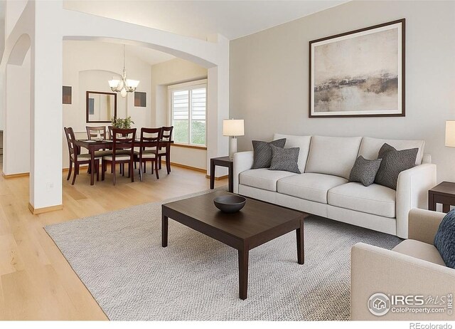13673 Cook St, Thornton, CO 80602 - living area featuring arched walkways, light wood finished floors, and a chandelier