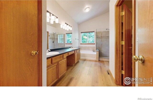 13673 Cook St, Thornton, CO 80602 - full bath featuring lofted ceiling, a shower stall, a garden tub, double vanity, and wood finished floors