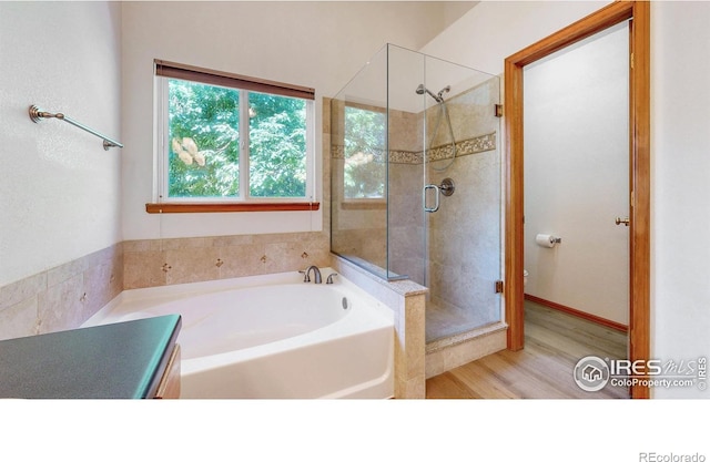 13673 Cook St, Thornton, CO 80602 - bathroom featuring a garden tub, a stall shower, and wood finished floors