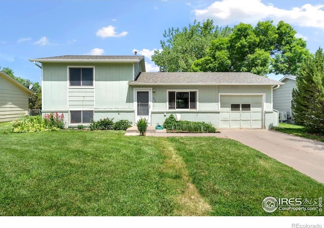 2424 W Stuart St, Fort Collins, CO 80526 - tri-level home featuring concrete driveway, an attached garage, a front lawn, and brick siding
