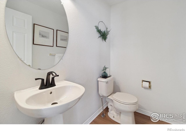3931 Stonegrass Pt, Broomfield, CO 80023 - half bathroom featuring toilet and wood finished floors